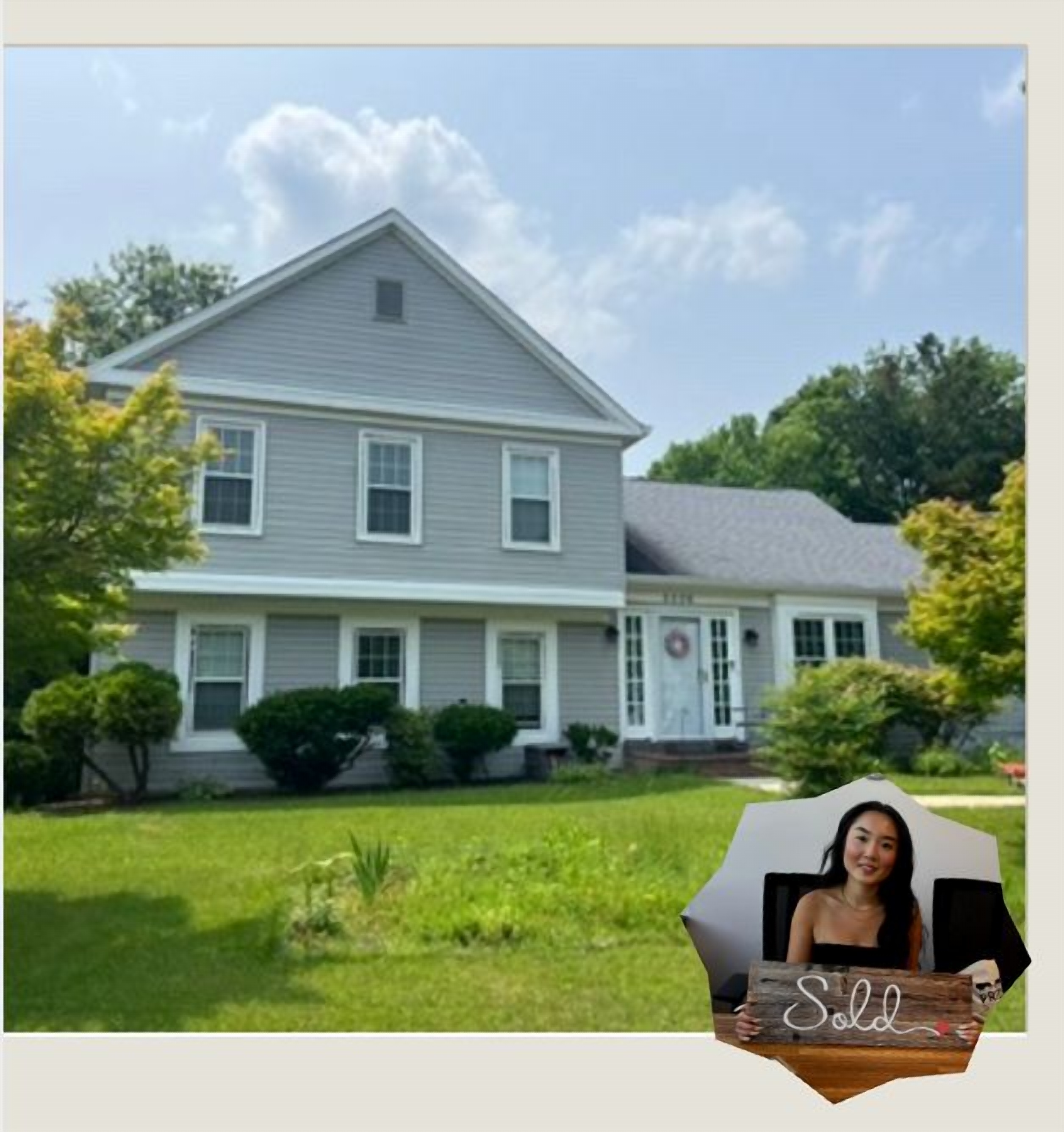 Sarah, founder of Solace and Sold, holding a Sold sign in front of a recently sold house
